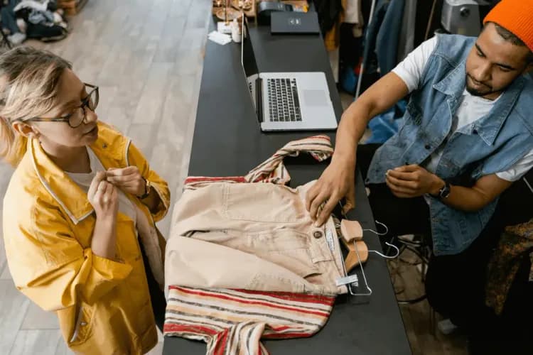 A cashier selling clothes to a woman